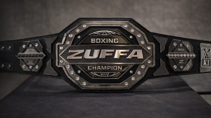 Gros plan de la ceinture de championnat Zuffa Boxing de forme octogonale avec des détails en diamant et « ZUFFA » sur la plaque centrale