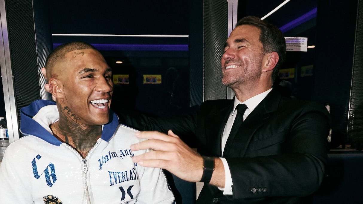 Conor Benn and Eddie Hearn smiling together backstage during a boxing event prior to Benn’s promotional split