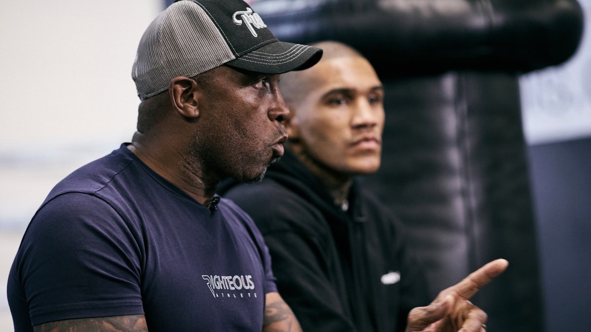 Nigel Benn speaks while son Conor Benn listens during a training session