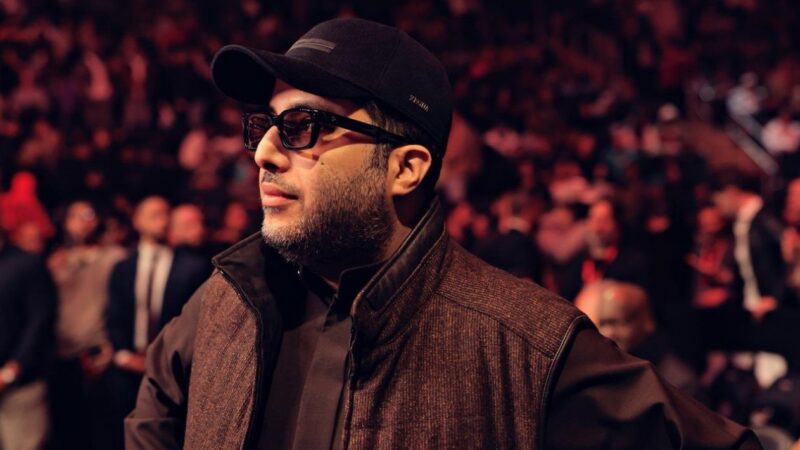 Turki Alalshikh assiste à un événement majeur de boxe, debout au bord du ring devant une salle comble.