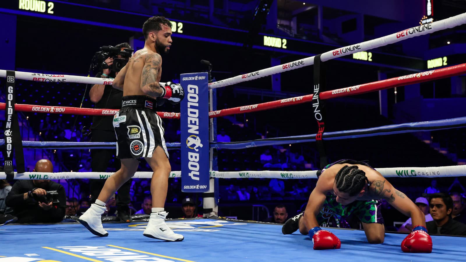 Oscar Collazo stands over Neider Valdez after scoring a knockdown during their flyweight bout in Oceanside, California
