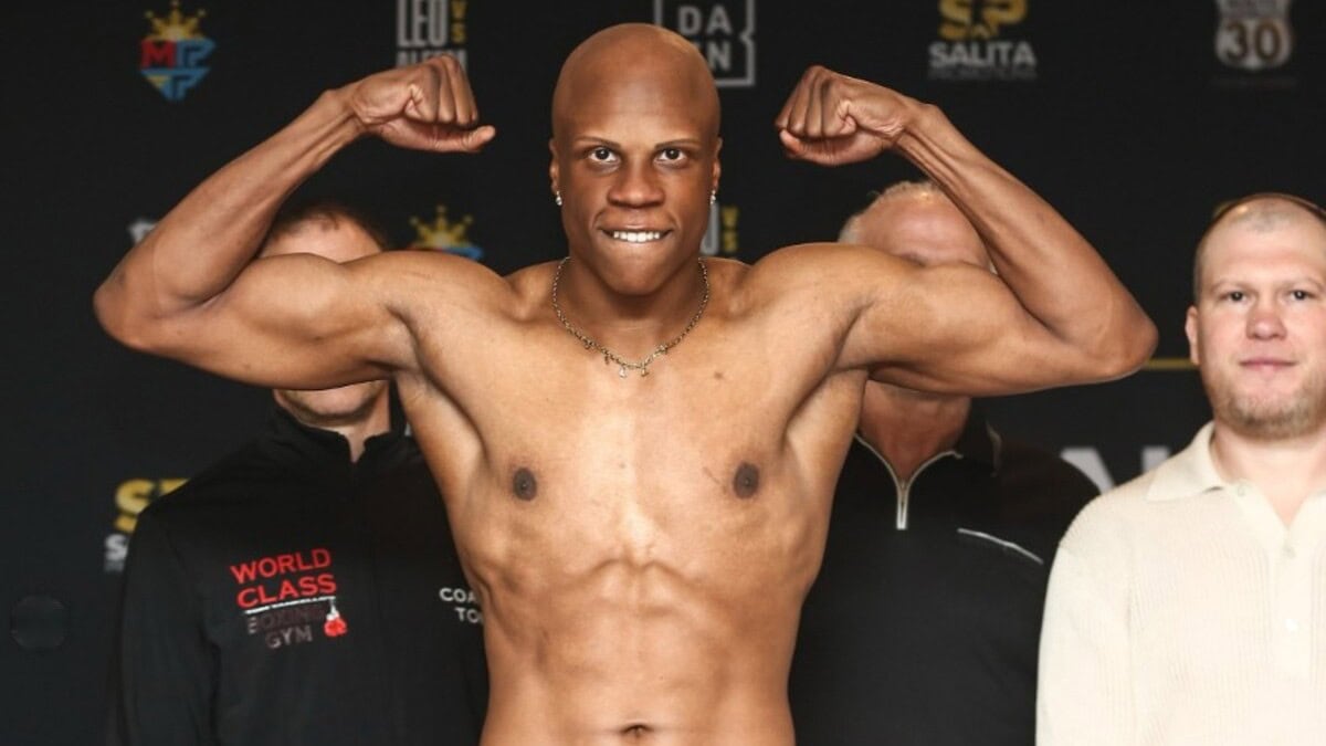 Atif Oberlton flexes during an official weigh-in with Dmitriy Salita standing behind him.