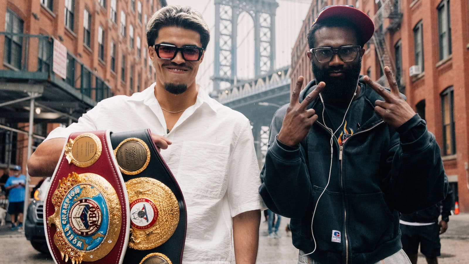 Xander Zayas and Jaron Ennis pose with world title belts during fight week in Brooklyn before their super welterweight title fight