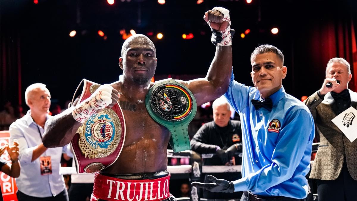 Gustavo Trujillo celebrates victory with championship belts after his first-round knockout win over Sergio Ramirez Marin in Fort Lauderdale.