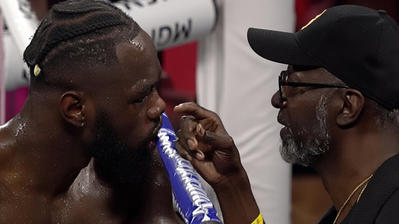 Mark Breland speaks to Deontay Wilder after throwing in the towel
