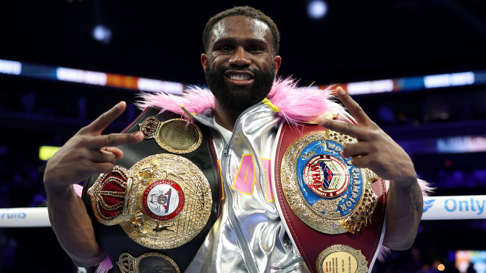 Jaron Ennis poses with the WBA and WBO super welterweight championship belts after defeating Xander Zayas in Brooklyn