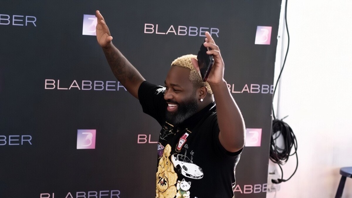 Adrien Broner smiles with his hands raised during a police raid