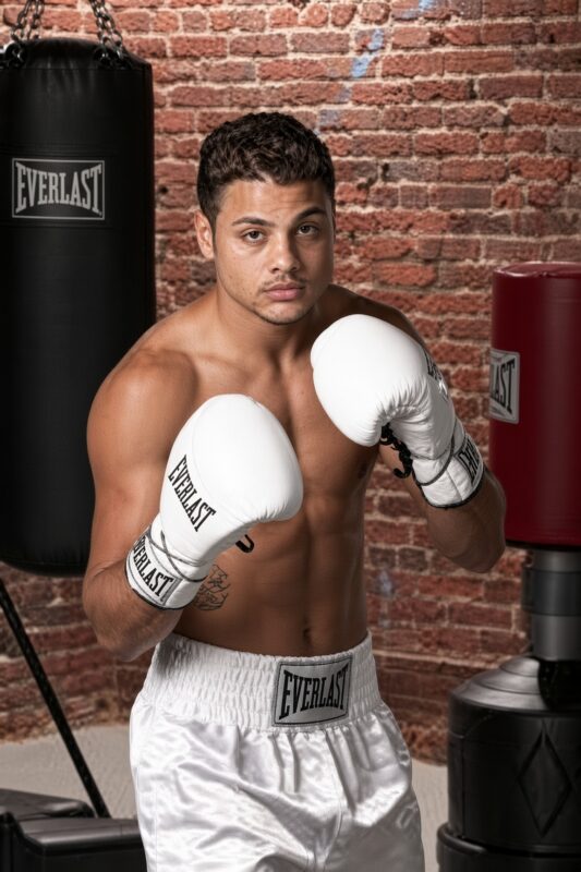 Ahmad Babyface Kaddour posant avec des gants de boxe et un caleçon blanc pour la saison 1 de The Contender